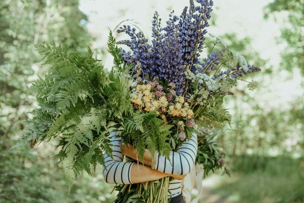 a woman holding a bunch of flowers in her hands